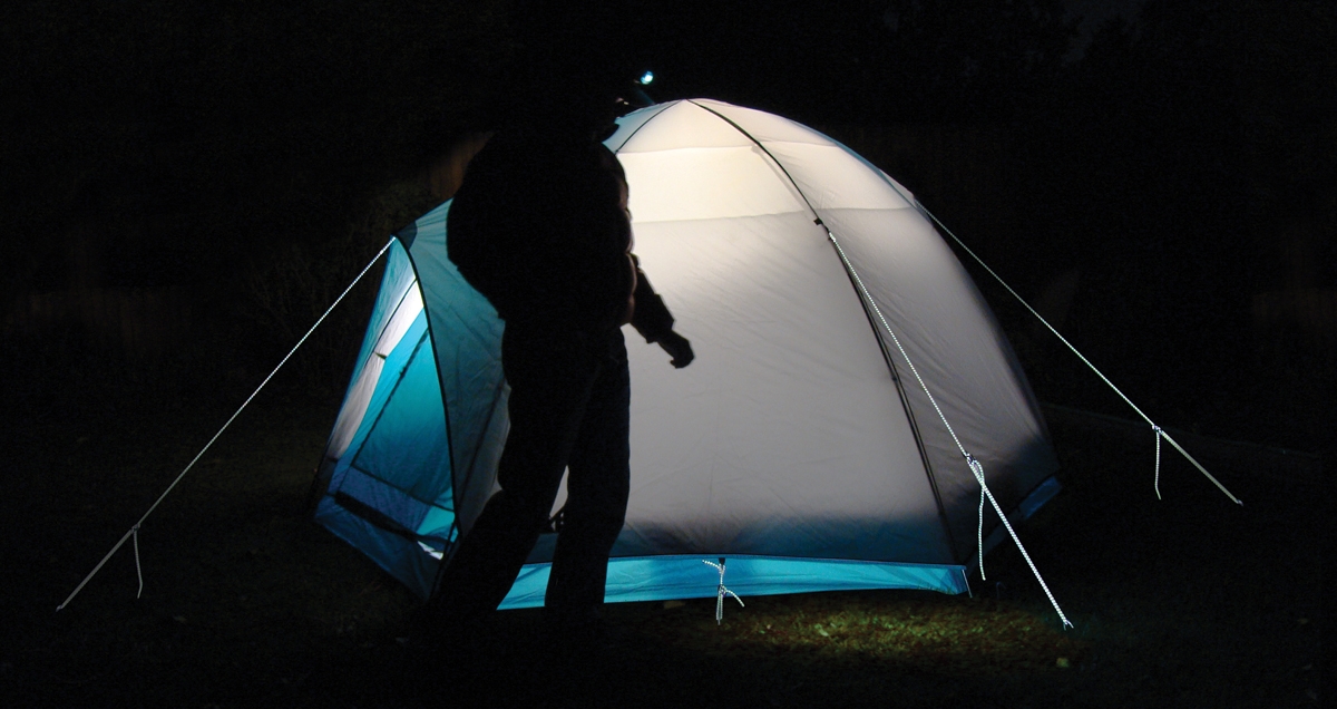 Camping tent at night with reflective tent lines