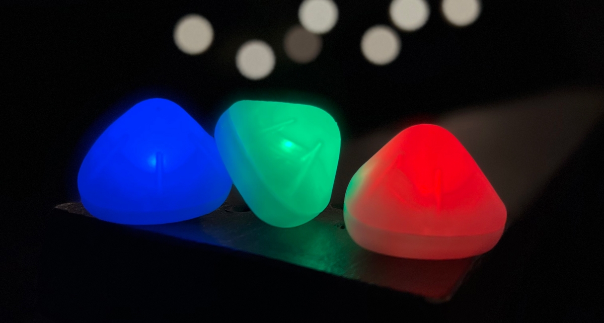 Three NiteGem LED Luminaries sitting on table in the dark