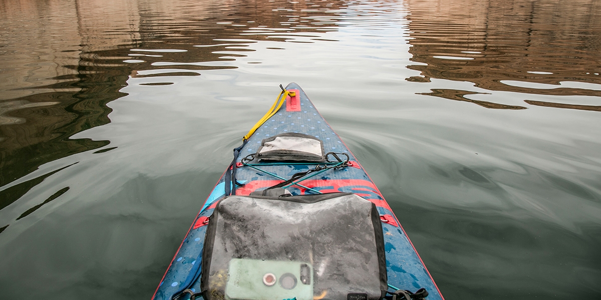 Packed RunOff Waterproof Bags on a paddle board